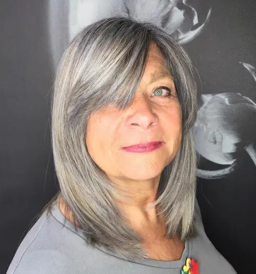 Mittellanges Haar mit dickem Seitenscheitel Stufig fransige Frisuren für Frauen ab 50 die jünger machen