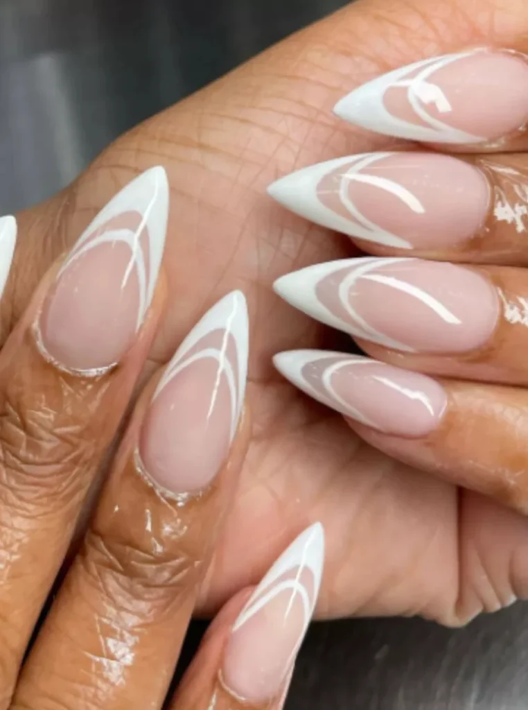 Double weiße French Nägel mit modernem Swirl-Design und glänzendem Nude-Finish auf langen mandelförmigen Nägeln.