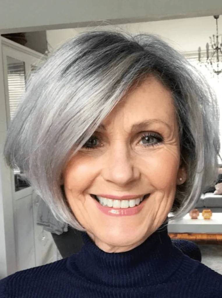 Frau über 60 mit französischem Bob in Silbergrau, voluminöser Kurzhaarschnitt mit seitlichem Pony für einen eleganten und jugendlichen Look.