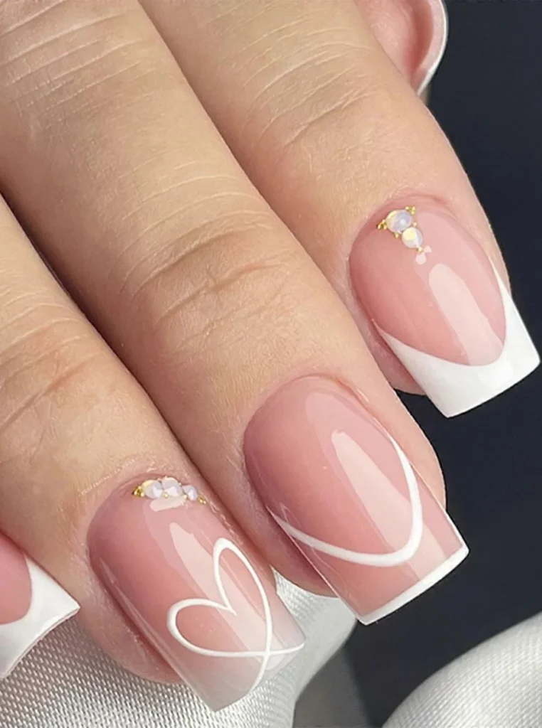 Herz weiße French Nägel mit glänzendem Nude-Finish, weißem Herz-Design und eleganten square Nägeln.