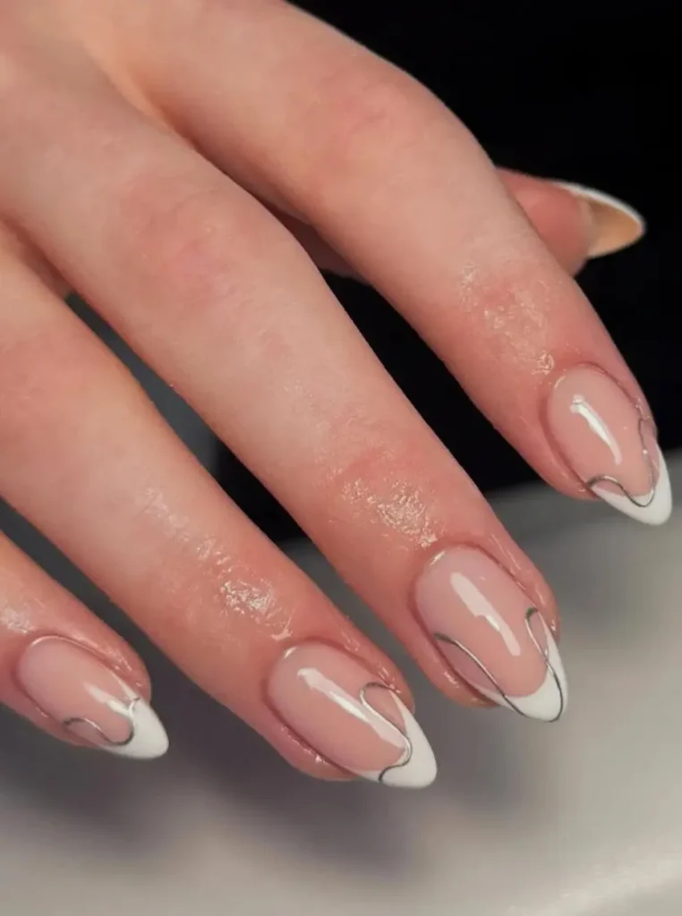 Mandel weiße French Nägel mit feinen silbernen Linien und glänzendem Nude-Finish in elegantem modernem Design.