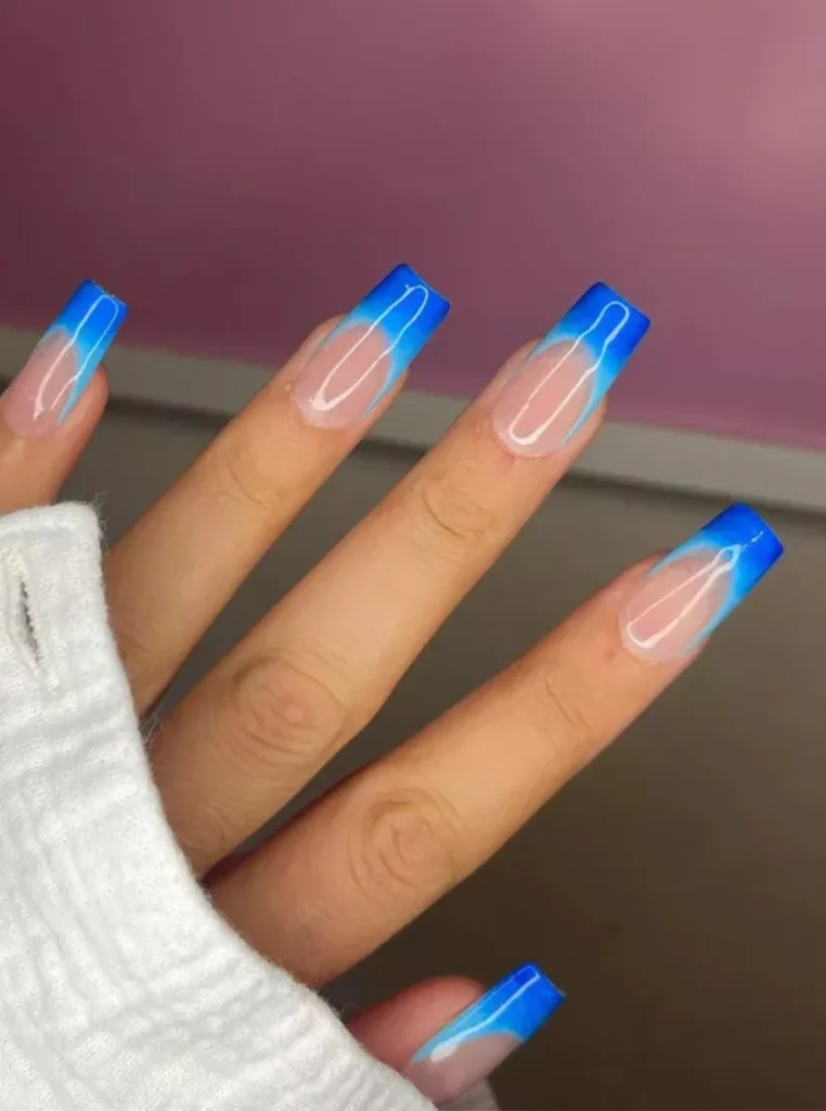 Trendige Nägel French Farbe mit leuchtend blauen French Spitzen auf langen eckigen Nude Nägeln