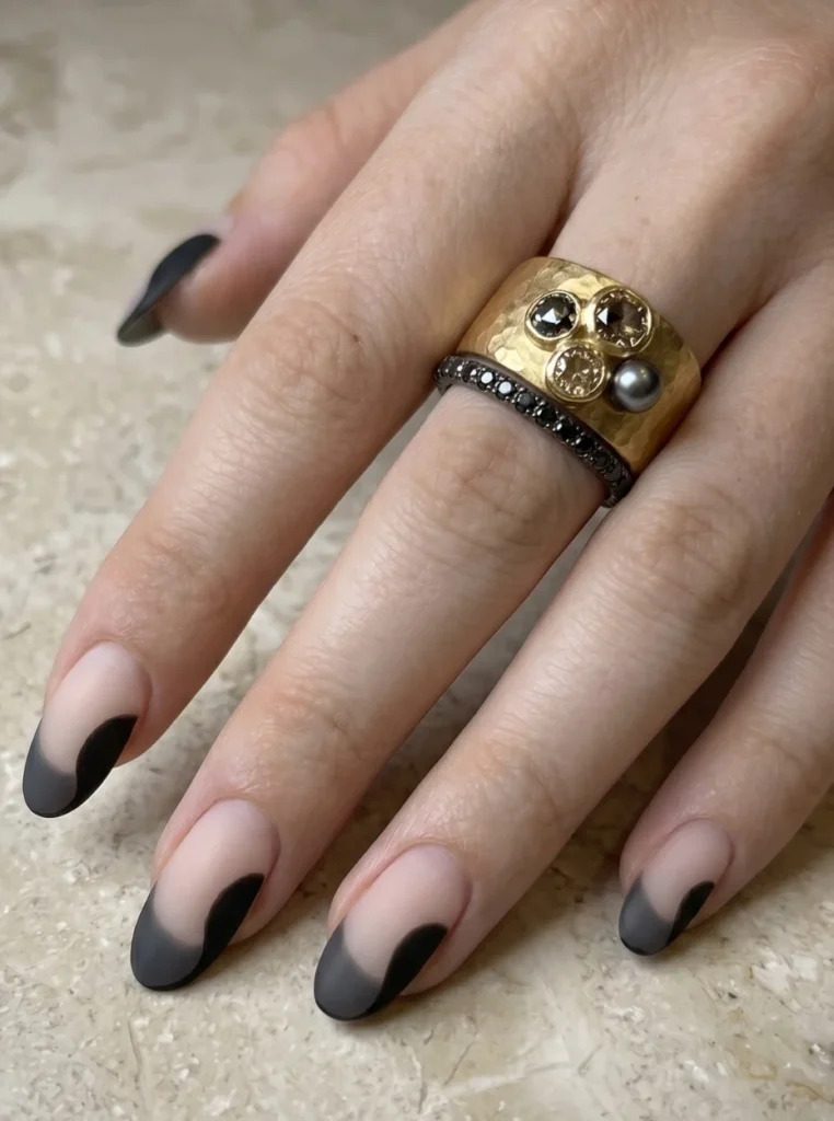 Moderne matte Nägel French Farbe mit schwarzen Spitzen auf eleganten mandelförmigen Nude Nägeln