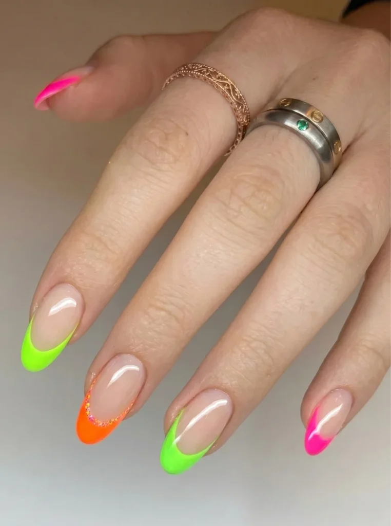 Trendige Nägel French Farbe mit neonfarbenen Spitzen in Pink, Grün und Orange auf glänzenden mandelförmigen Nägeln
