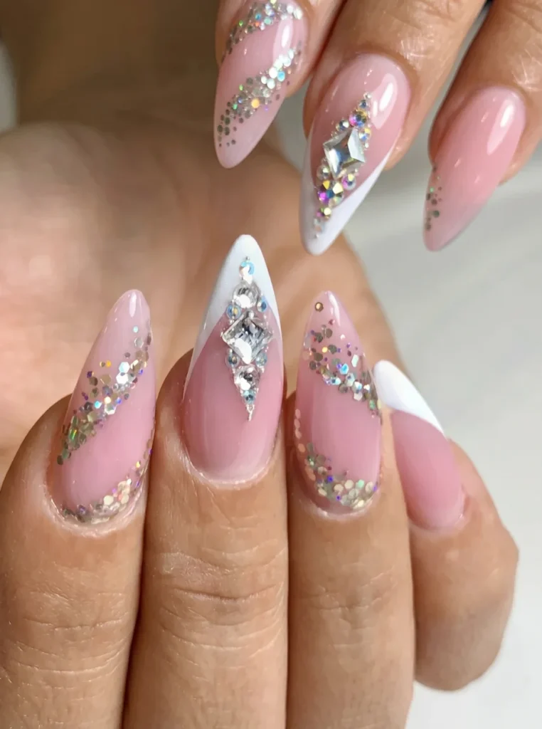 Elegante French Nails mit Strasssteinen und funkelnden Glitzerdetails auf langen mandelförmigen Nägeln in luxuriöser Nahaufnahme