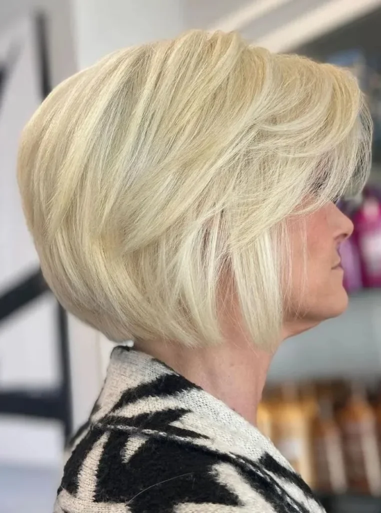 Frau über 60 mit strukturiertem Bob, hellblondem Haar und voluminösen Stufen für mehr Fülle, Bewegung und einen modernen Look.