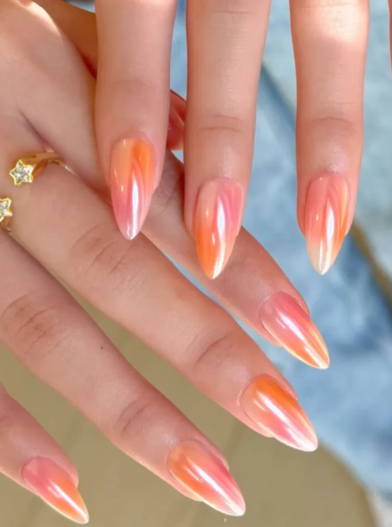 Glazed Apricot Nägel mit Ombre-Effekt und spiegelndem Chrome-Finish auf mandelförmigen Nägeln.