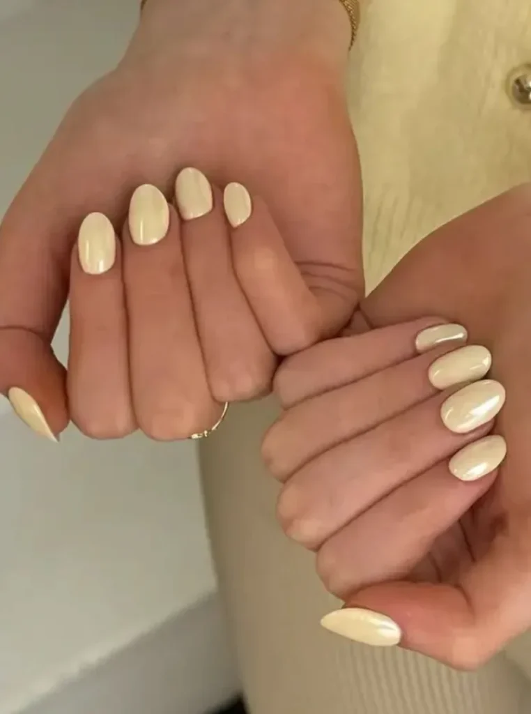Butter Yellow Chrome Nails mit glänzendem Perlmutt-Effekt auf ovalen Nägeln – elegantes minimalistisches Nageldesign