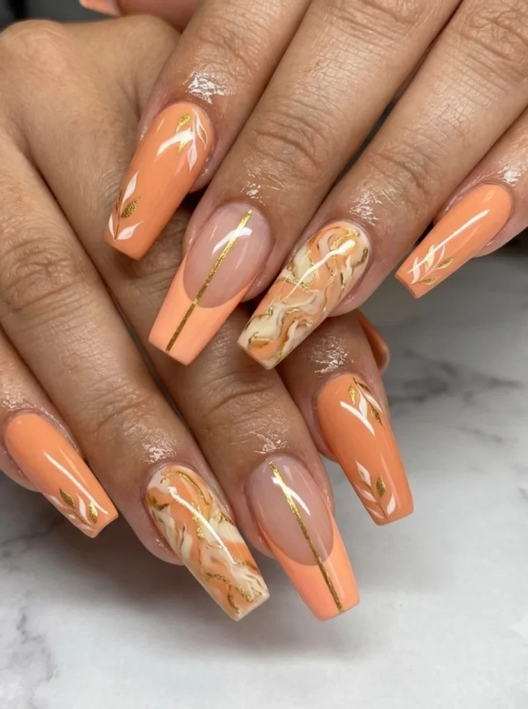 Apricot Coffin Nägel mit Marmoreffekt, goldenen Linien und floralen Details auf langen eckigen Nägeln.