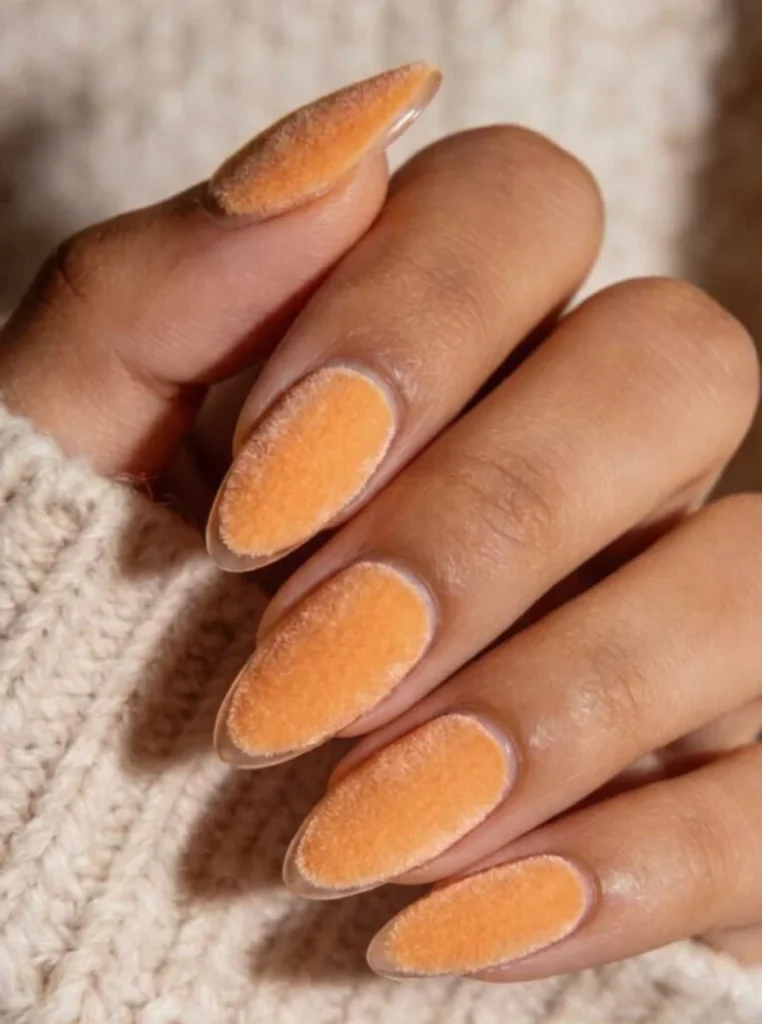 Apricot Velvet Nägel mit samtigem Matteffekt auf langen mandelförmigen Nägeln in warmem Apricot-Ton.