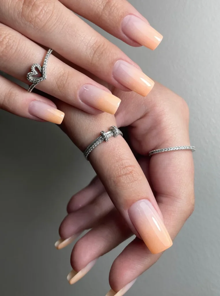 Babyboomer Pfirsich Nägel mit sanftem Farbverlauf von Nude zu Apricot auf eckigen Nägeln.