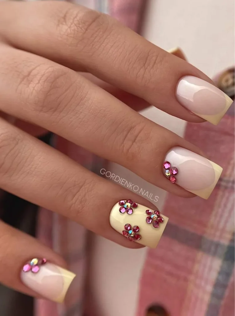 Butter Yellow French Nails mit zarten gelben Spitzen und rosa Strasssteinen auf quadratischen Nägeln