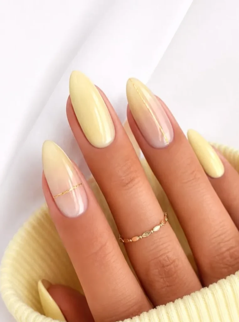 Butter Yellow Ombre Nails mit sanftem Farbverlauf und feinen Goldlinien auf mandelförmigen Nägeln