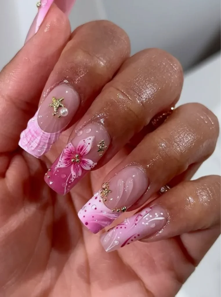 Jelly Pink Nails mit rosa Blumen-Nail-Art, transparentem Gel-Effekt und goldenen Verzierungen auf langen Square Nails.