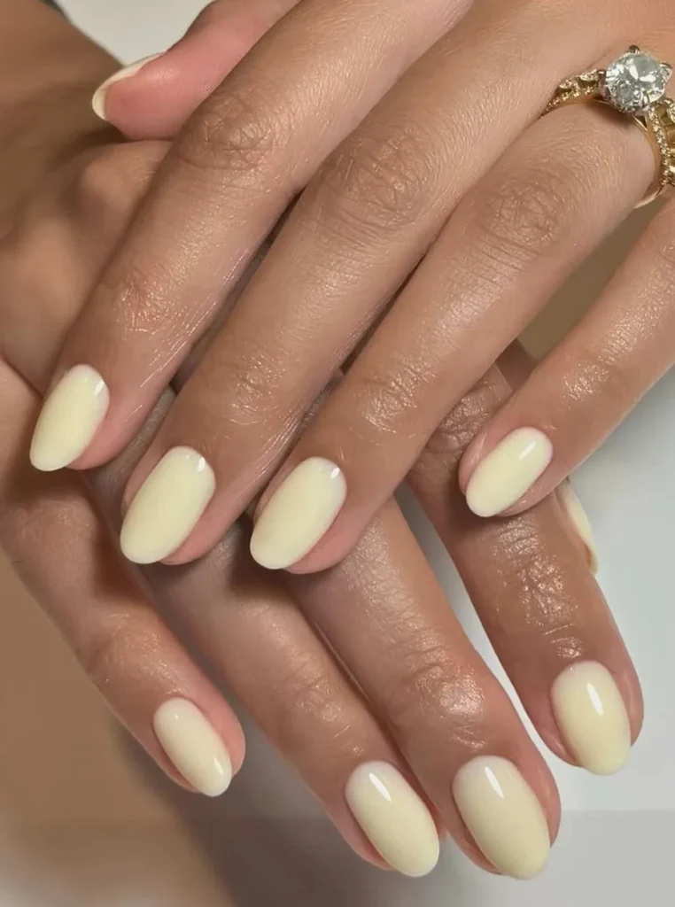 Klassischer Butter Yellow Nagel in glänzendem Finish auf ovalen Nägeln – elegantes und minimalistisches Nageldesign