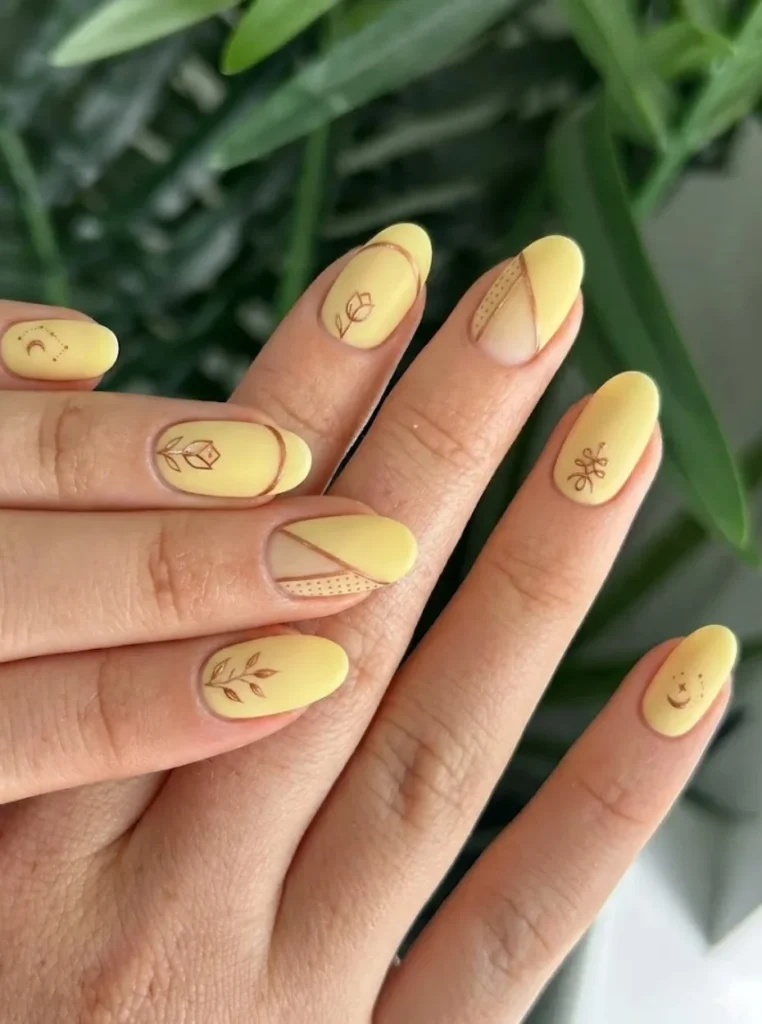 Matte Butter Yellow Nägel mit minimalistischer Nail Art und feinen floralen Linien auf mandelförmigen Nägeln