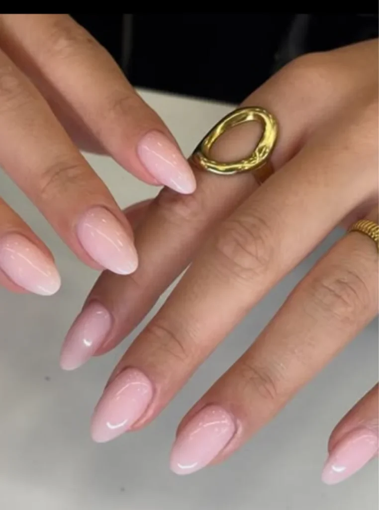Elegante Milky Pink Nägel in zartem Rosa mit glänzendem Finish und mandelförmiger Nagelform – moderner Sommer-Nageltrend.