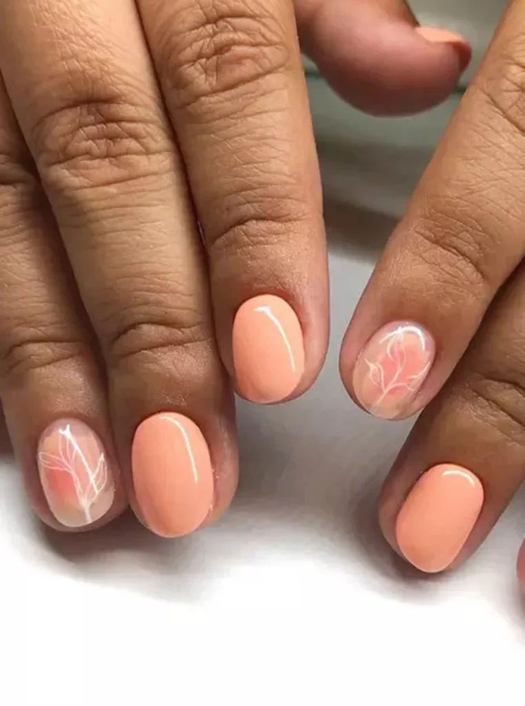 Minimalistische Pfirsich Nägel mit zartem Blattmuster und glänzendem Finish auf kurzen ovalen Nägeln.