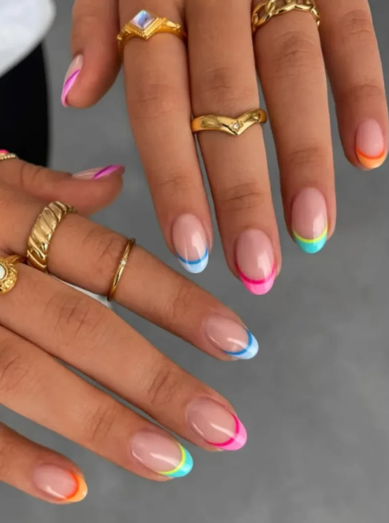 French Nails mit bunten Spitzen in Pink, Blau, Gelb, Orange und Türkis auf natürlichen mandelförmigen Nägeln – moderner Frühlingslook 2026.