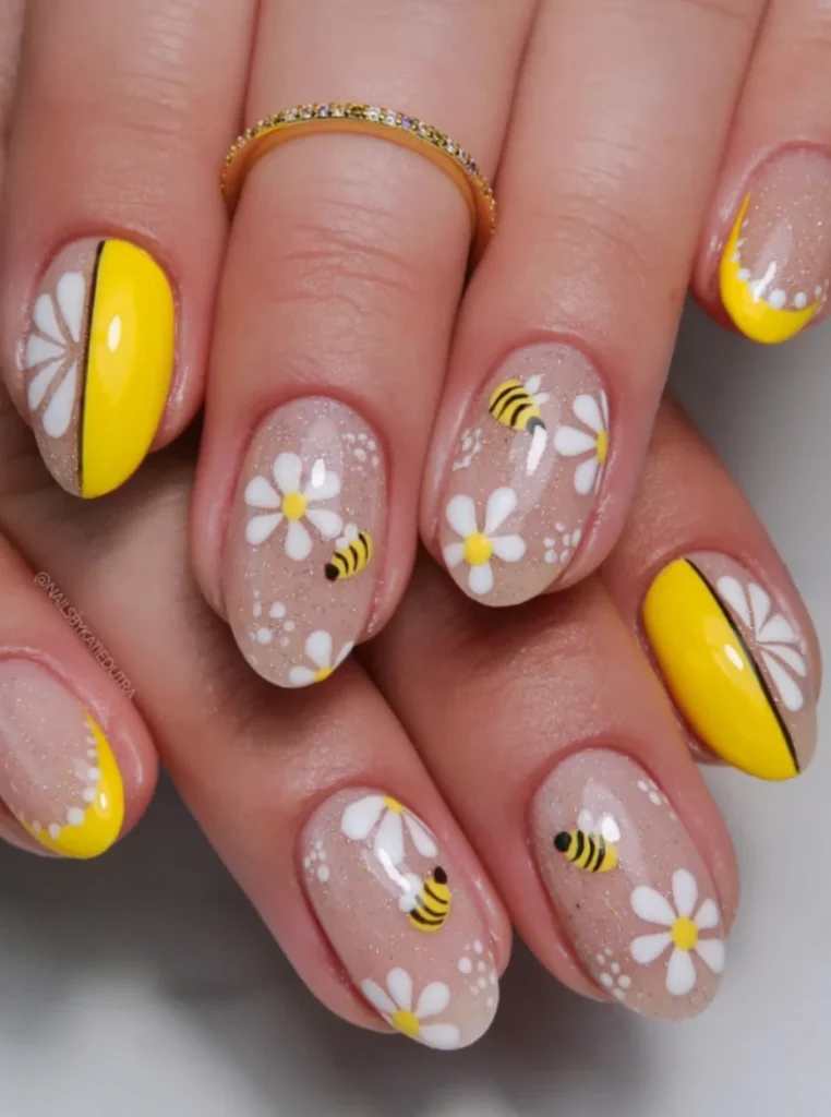 Gänseblümchen-Nägel mit süßen Bienen, gelben Akzenten und glitzernder Nude-Basis – fröhliches Frühlings-Nageldesign 2026.