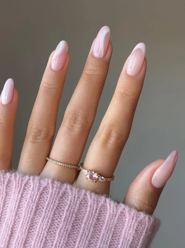 Pastellrosa Nägel mit glänzendem Finish und elegantem Wellendesign auf mandelförmigen Nägeln – trendige Frühlingsnägel 2026.
