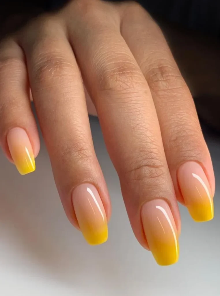 Ombre gelb French Nägel mit sanftem Farbverlauf von Nude zu Sonnengelb auf kurzen eckigen Nägeln.