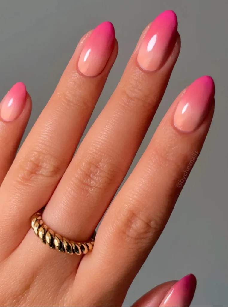 Rosa Ombre Nägel mit sanftem Farbverlauf von Nude zu kräftigem Pink auf mandelförmigen Nägeln – moderner Sommer-Nageltrend.