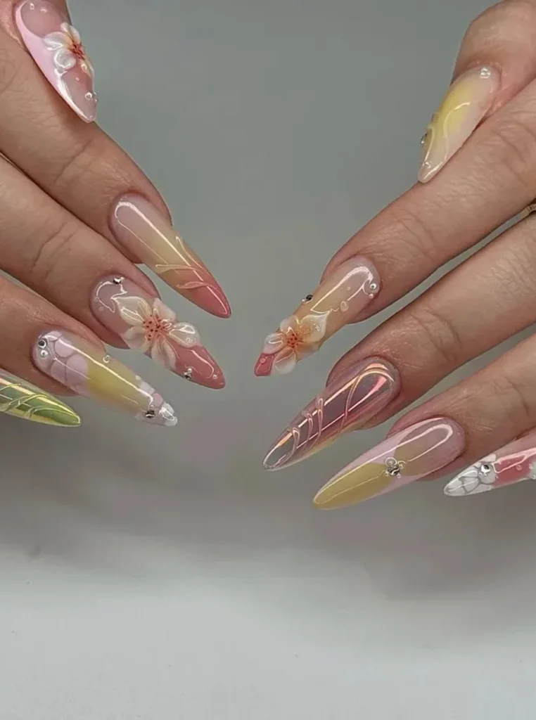 Pfirsich Nägel mit 3D-Blumen, Pastellfarben und filigranen Nail-Art-Details auf langen spitzen Nägeln.