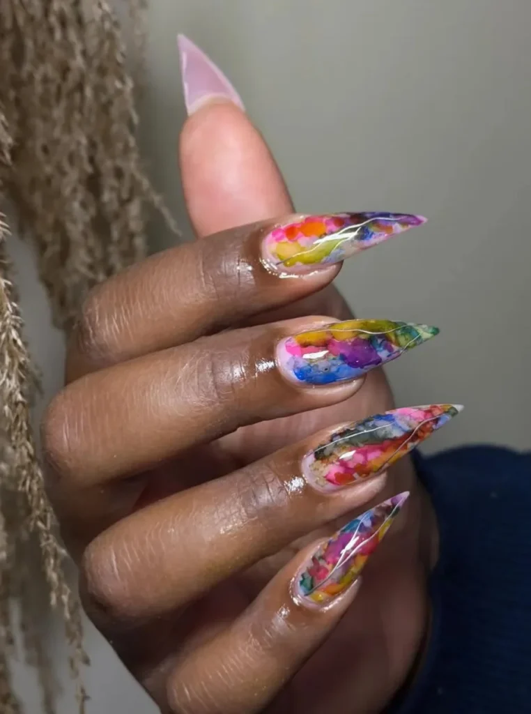 Rosa Aquarell-Blumen Nägel mit bunten watercolor Blütenmustern auf langen Stiletto-Nägeln, kreatives künstlerisches Nageldesign 2026