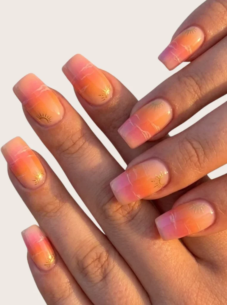 Rosa Sunset Nails mit rosa-orangefarbenem Farbverlauf und Sonnenuntergangs-Details auf quadratischen Nägeln – sommerlicher Nail-Art-Trend.